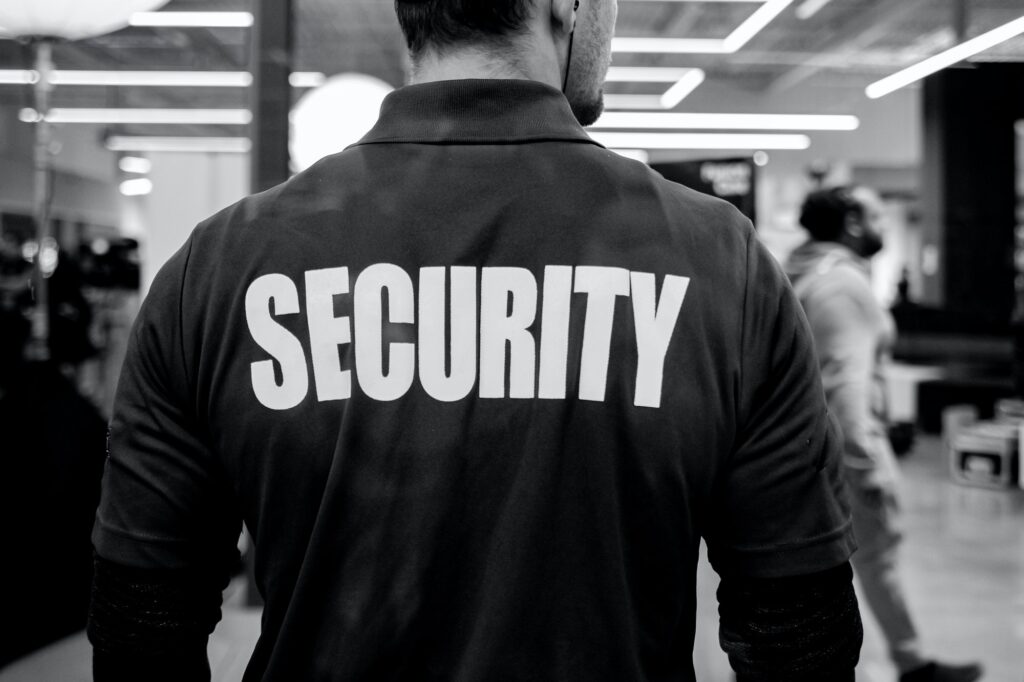 Grayscale shot of a security guard inside a commercial building